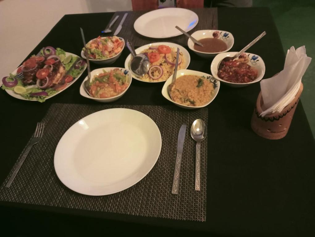 a table with plates and bowls of food on it at Talalla Mango House in Talalla South