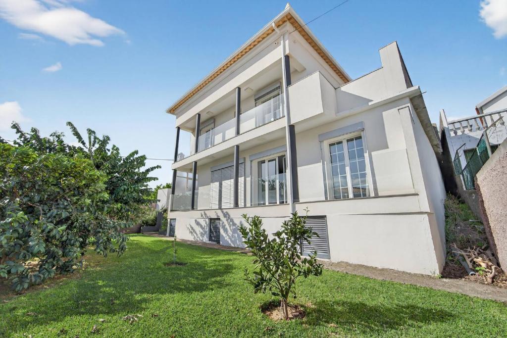 a white house with a tree in front of it at Florentina Villa in Gaula