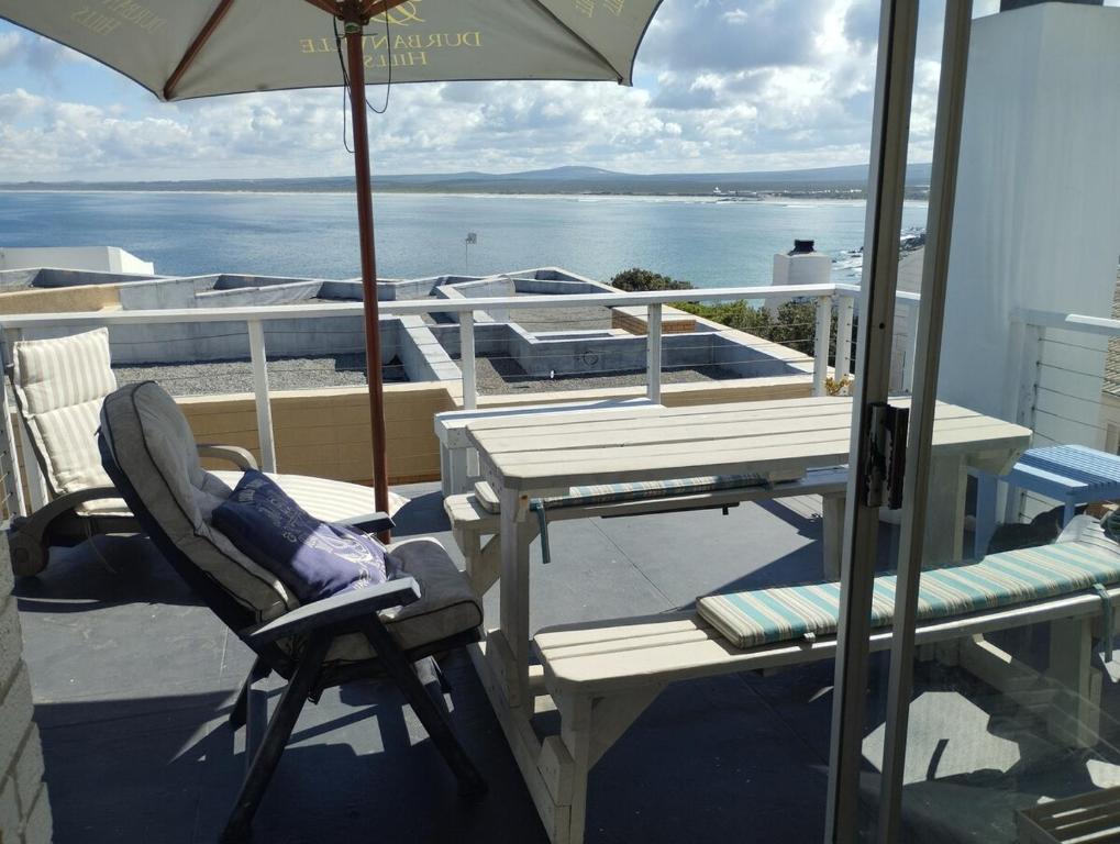 a patio with a table and chairs and an umbrella at Sea Echo in Yzerfontein