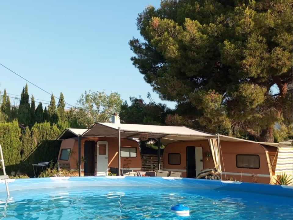 a house with a swimming pool in front of it at Caravana- Glamping Casa tortuga in La Nucía