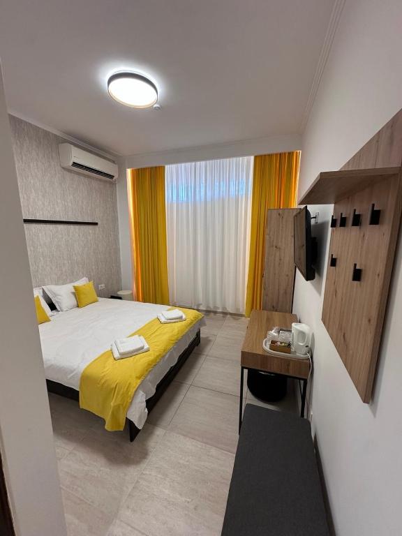 a bedroom with a bed and a desk in a room at Rulers Smart Rooms in Satu Mare