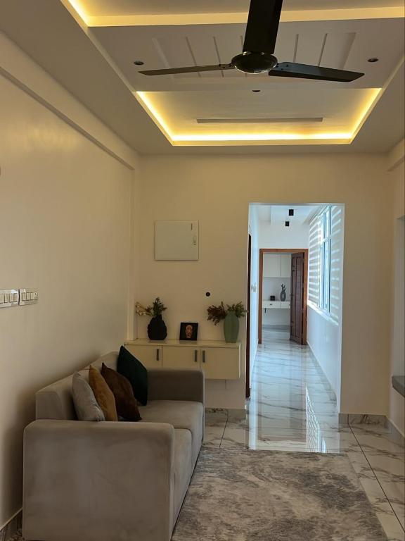 a living room with a couch and a hallway at Malhar Homes in Kozhikode