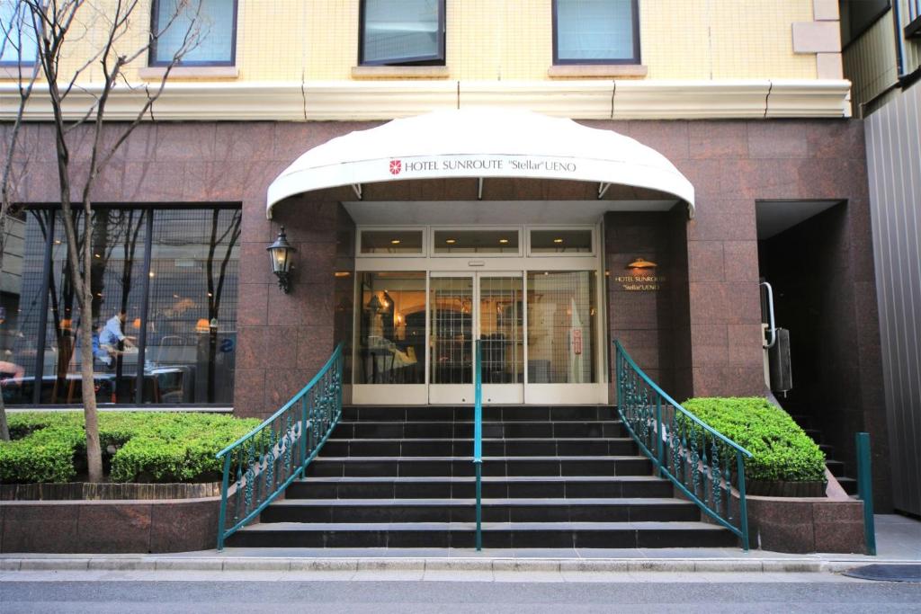 a building with a staircase leading to the front door at Hotel Sunroute Stellar Ueno in Tokyo