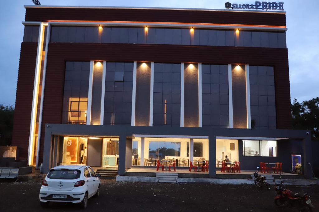 a white car parked in front of a building at Hotel Ellora Pride in Ellora
