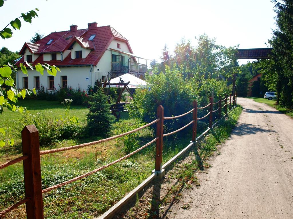una cerca frente a una casa al lado de una carretera en Apartament Skłodowo Mazury, en Harsz