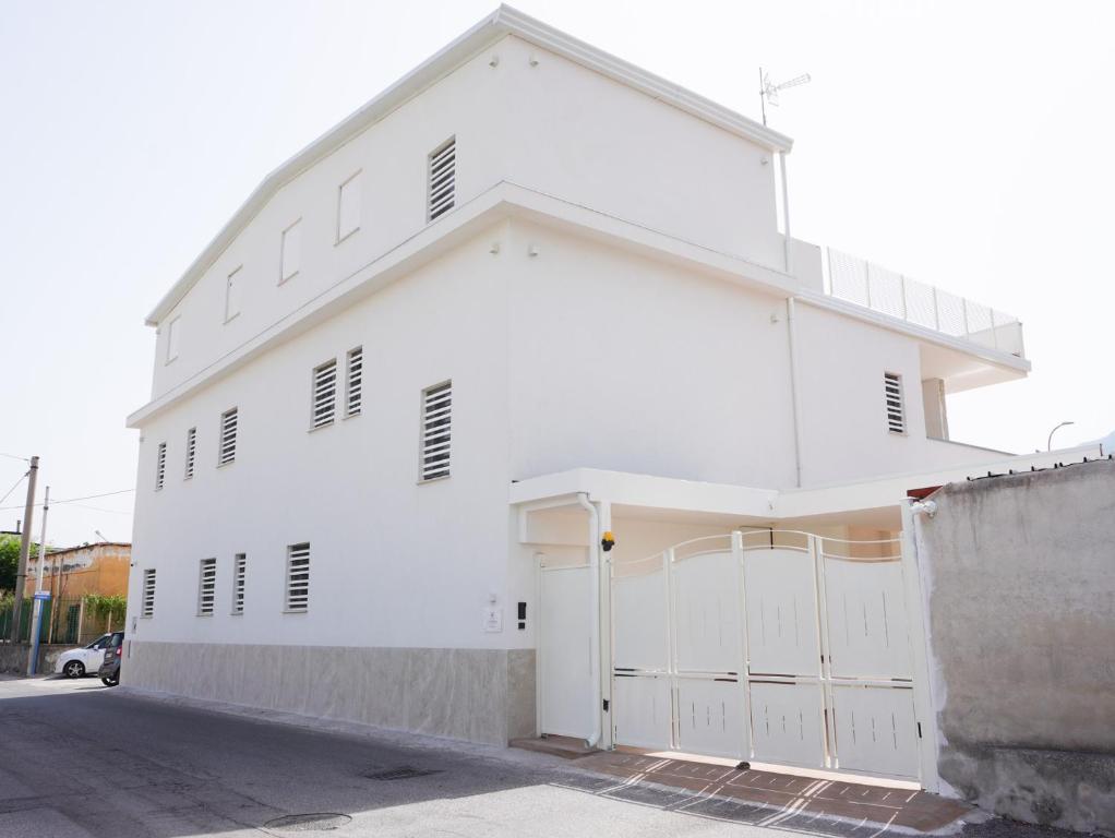 a white building with a garage at La Martina Guesthouse in Angri
