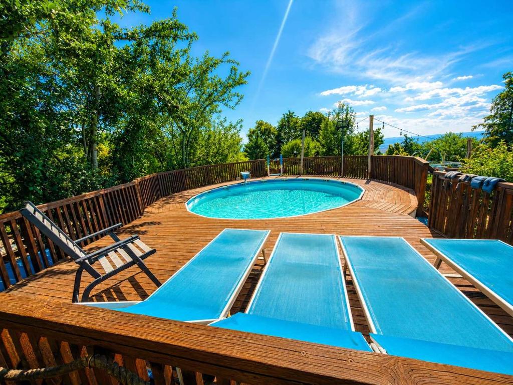 a pool on a wooden deck with two loungers around it at Paradise Villa in Gracanica