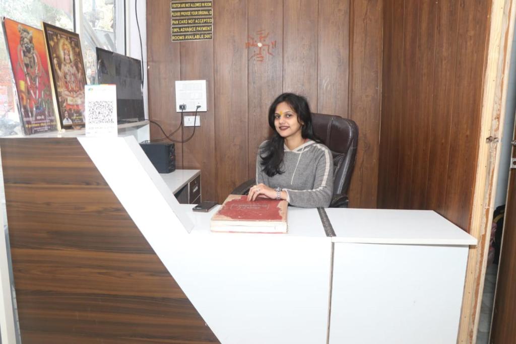 a woman sitting at a desk with a cake at Shri Ram seva sadan in Vrindāvan
