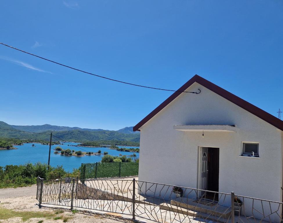 a small white house with a view of a river at Vuković house - Lake View & Nature in Kuside
