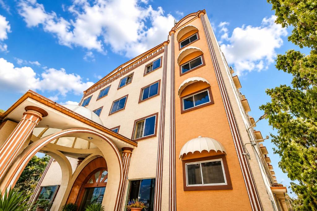 an orange building with an arch and a blue sky at SRS Jade Empire in Kammasandra