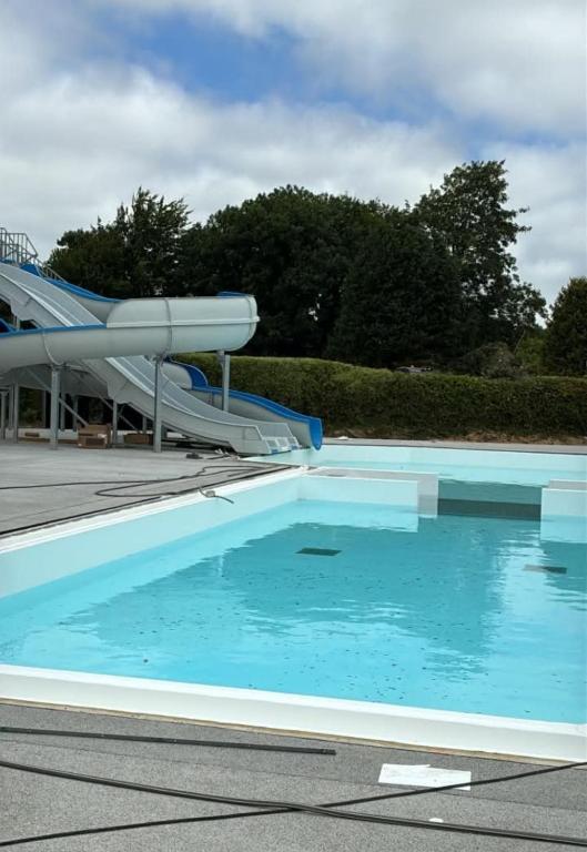 a swimming pool with a slide in the background at Far west location in Vironchaux