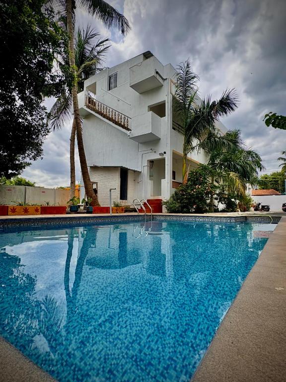 a large swimming pool in front of a house at Serenity beach side in Pondicherry