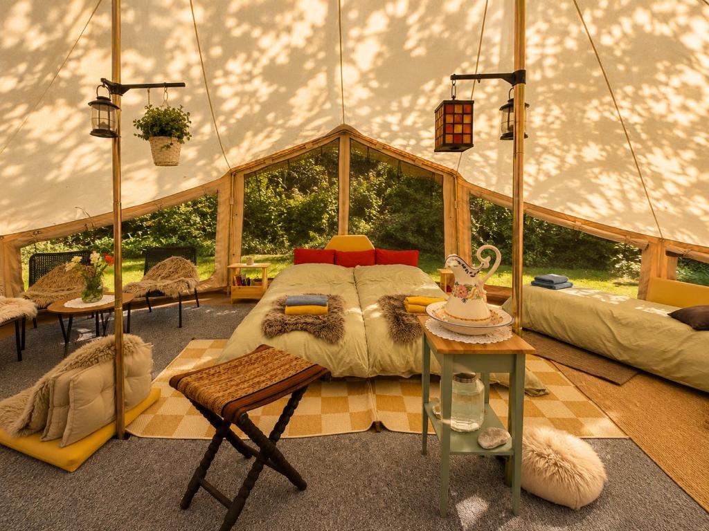 ein Schlafzimmer in einer Jurte mit einem Bett und einem Tisch in der Unterkunft Eden Baths in Averoy