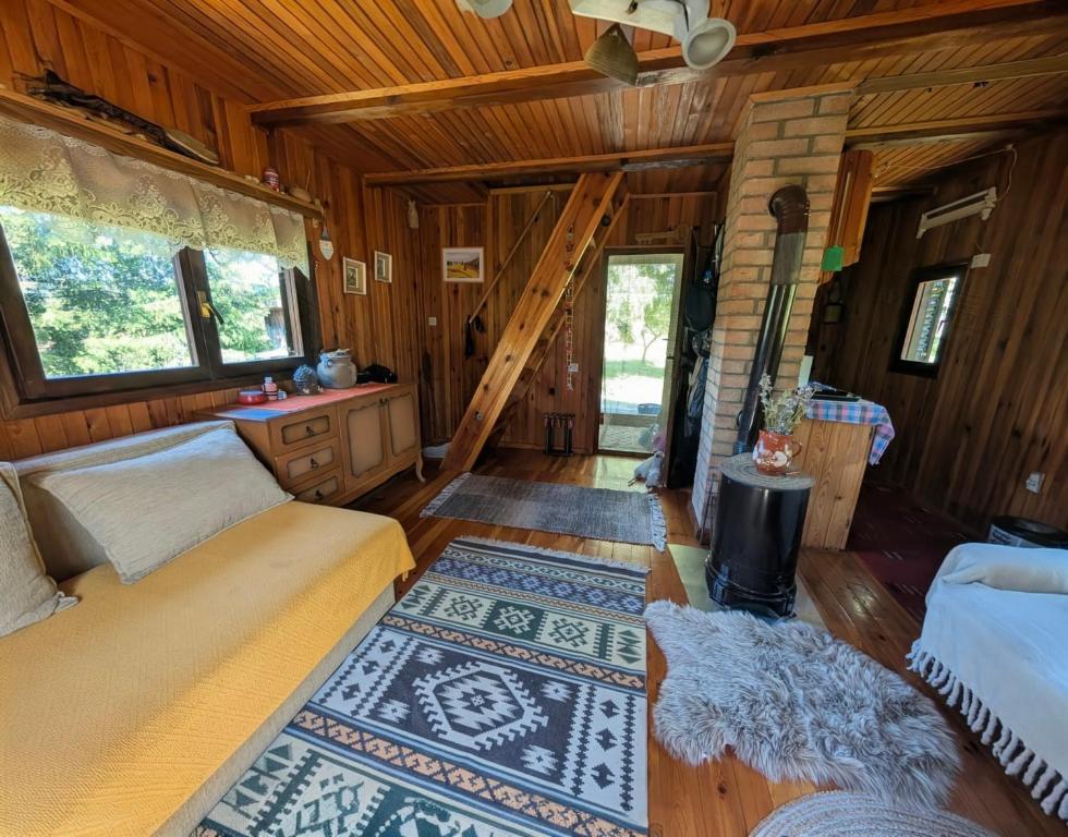 a living room with two beds and a staircase at Kremna Cottage in Kremna