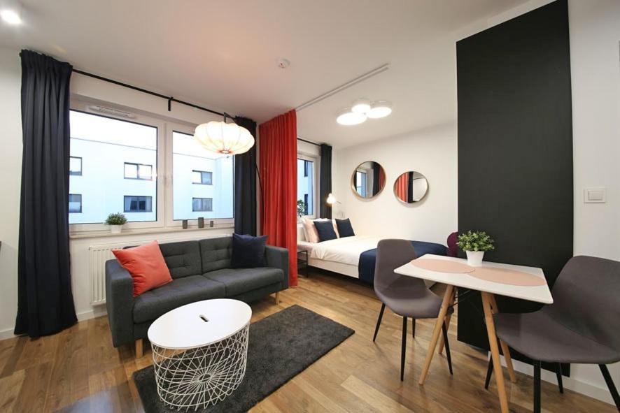 a living room with a couch and a bed at A very cozy apartment with a large bed in Wrocław