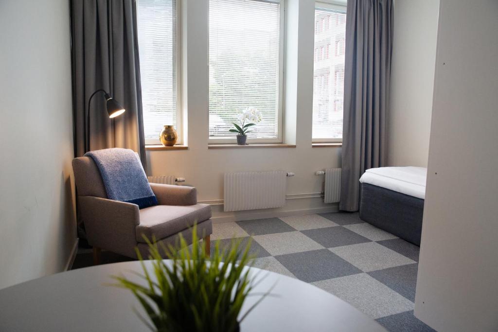 a hotel room with a bed and a chair and window at Biz Apartment Solna in Solna