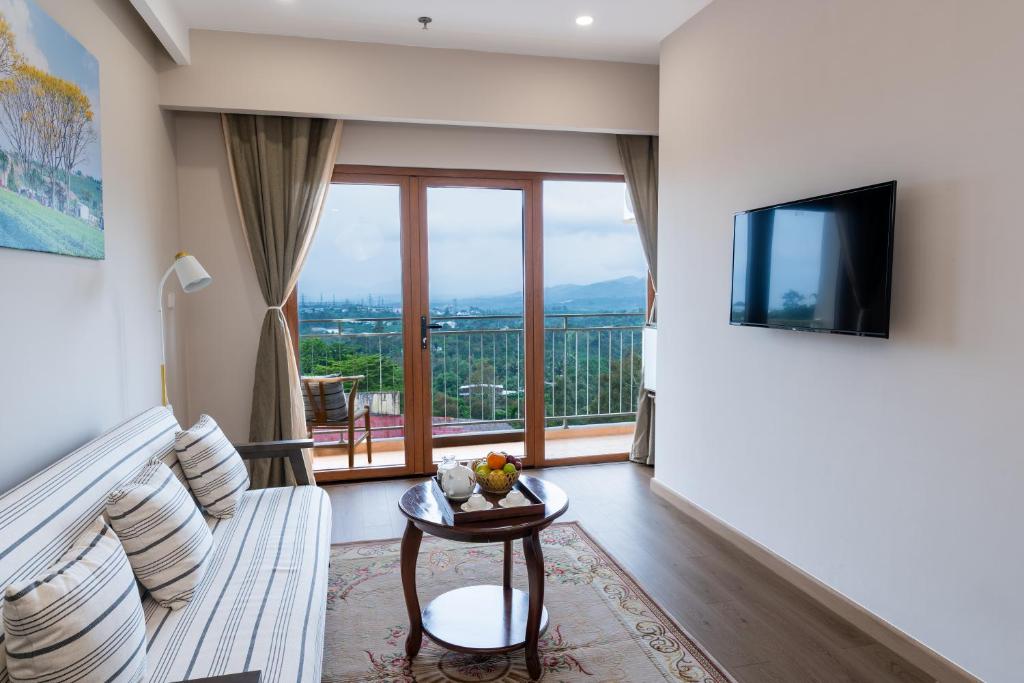 a living room with a couch and a large window at Memories Hotel in Bảo Lộc