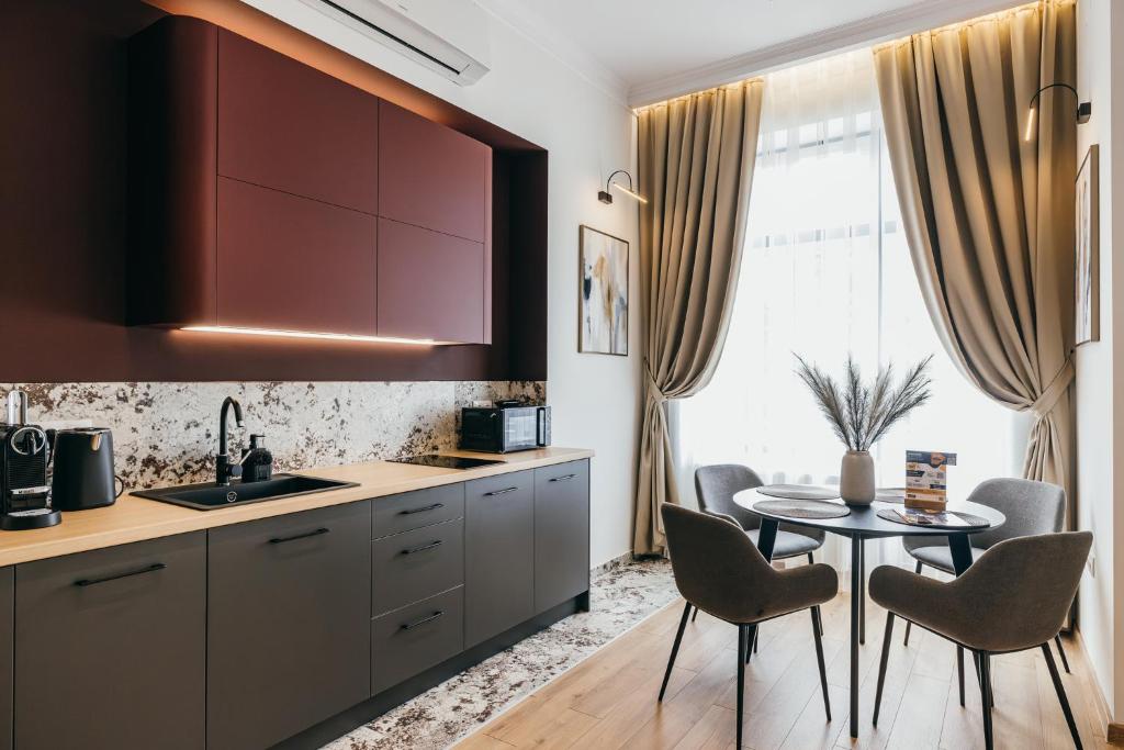 a kitchen with a table and chairs next to a window at NOZON Apartments & Wellness in Odorheiu Secuiesc