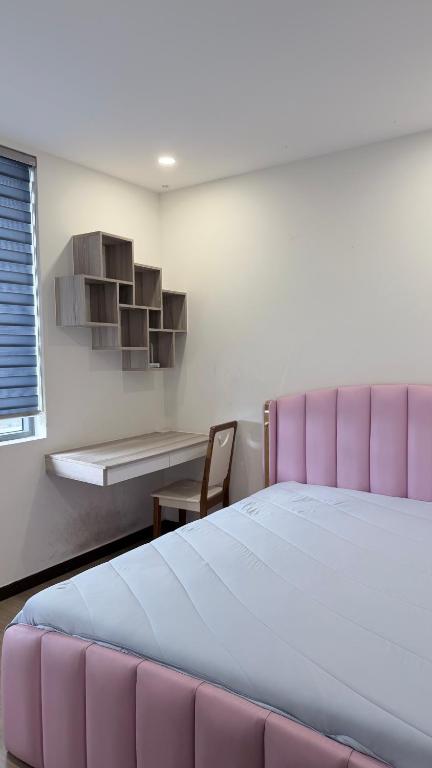 a bedroom with a large bed with a pink headboard at Chung cư Csky View in Ga Phú Văn