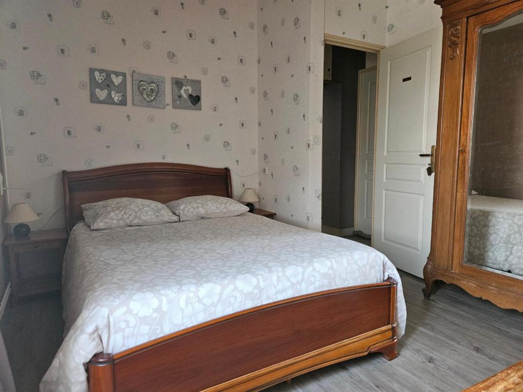 a bedroom with a bed with a wooden head board at Chambres d'hôtes -- Le Clos de Gémozac in Gémozac