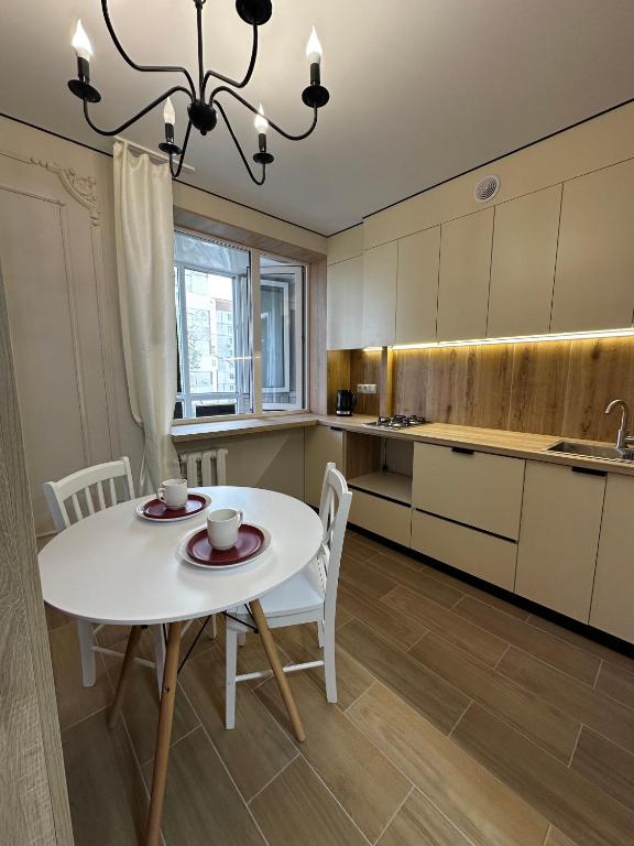 a kitchen with a white table and chairs in a room at Elegant Apartment City Center in Tiraspol