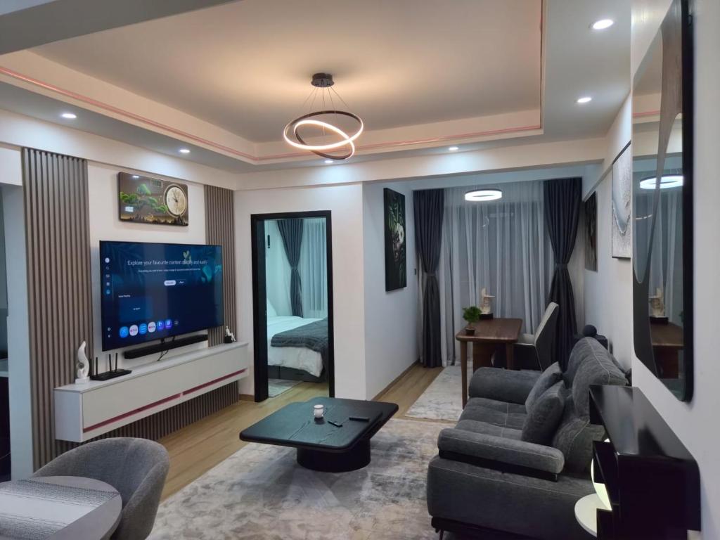 a living room with a couch and a tv at Smart Cloud Apartment in Nairobi