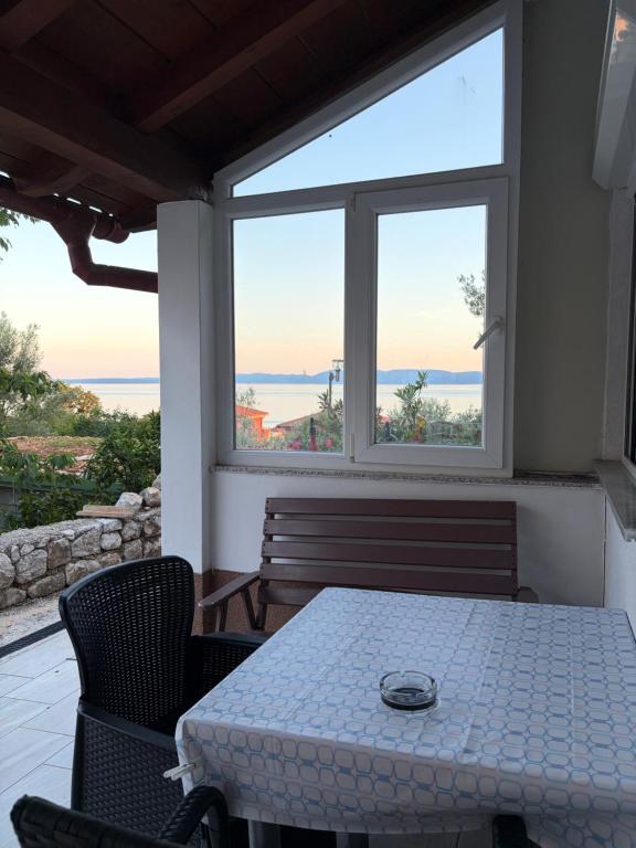 a table and chairs in a room with a window at Studio app Ana in Kostrena