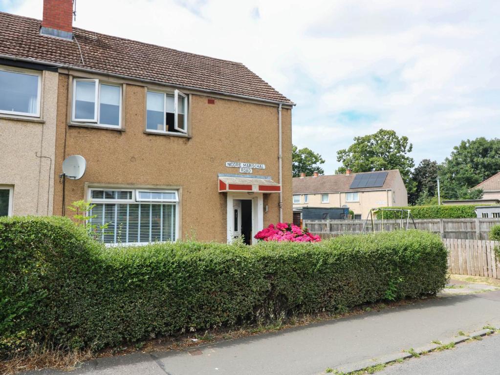 a house with a hedge in front of it at 6 Niddrie Marischal Road in Edinburgh