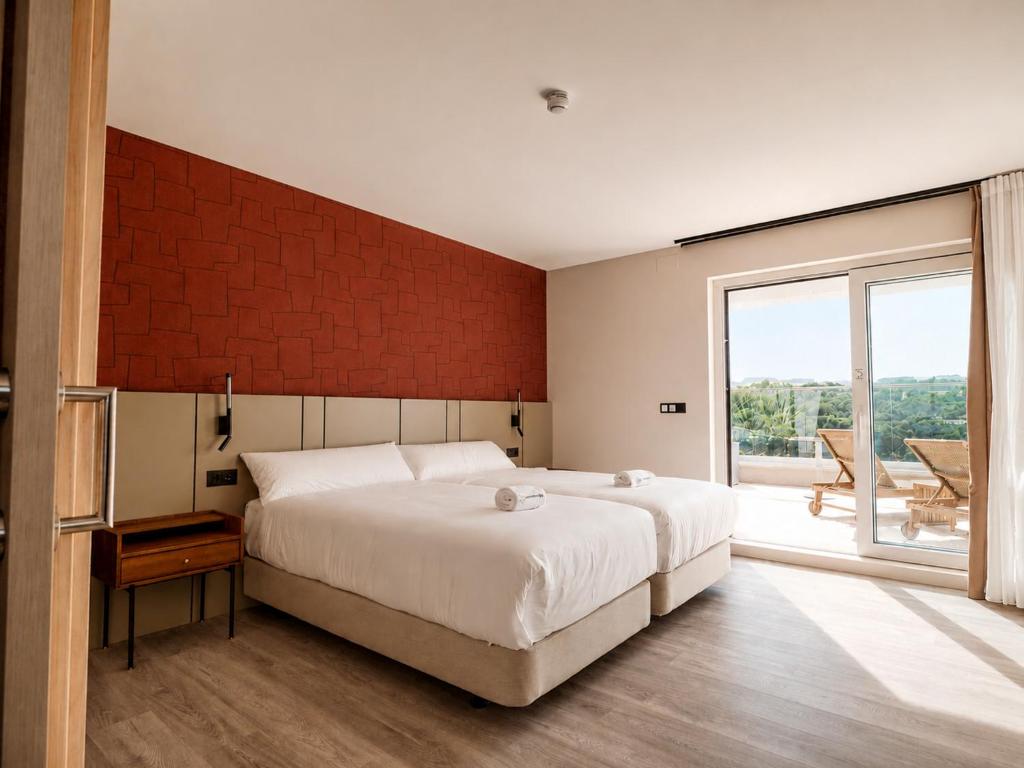 ein Schlafzimmer mit einem großen Bett und einem großen Fenster in der Unterkunft Hotel Henko in Portomarin