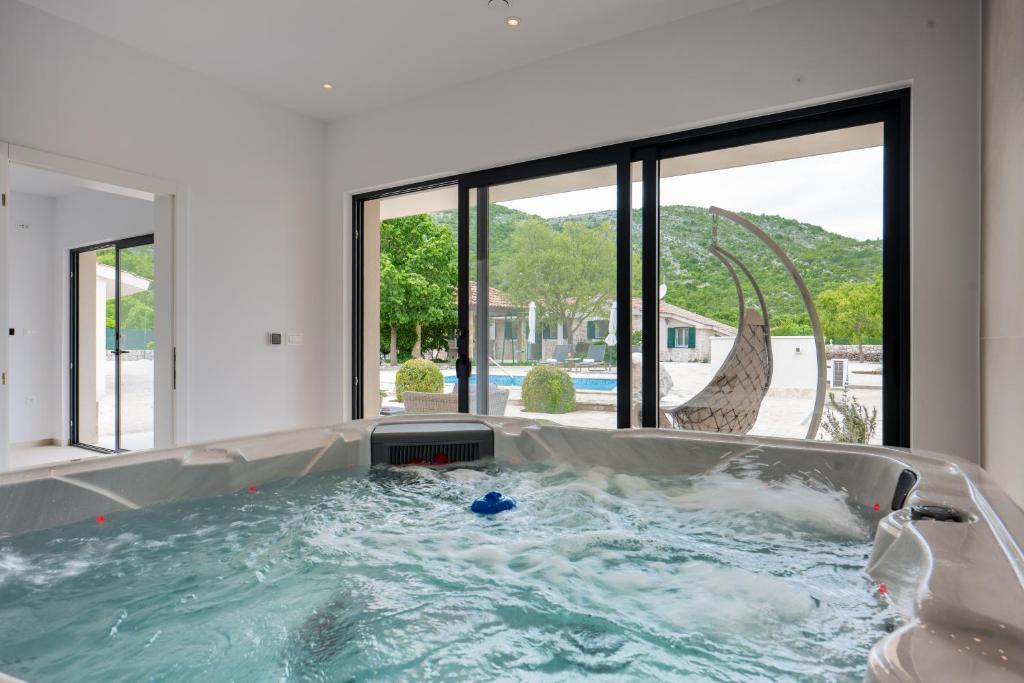 a jacuzzi tub in a house with a slide at Wellnes Villa Silentio With Pool in Duge Njive