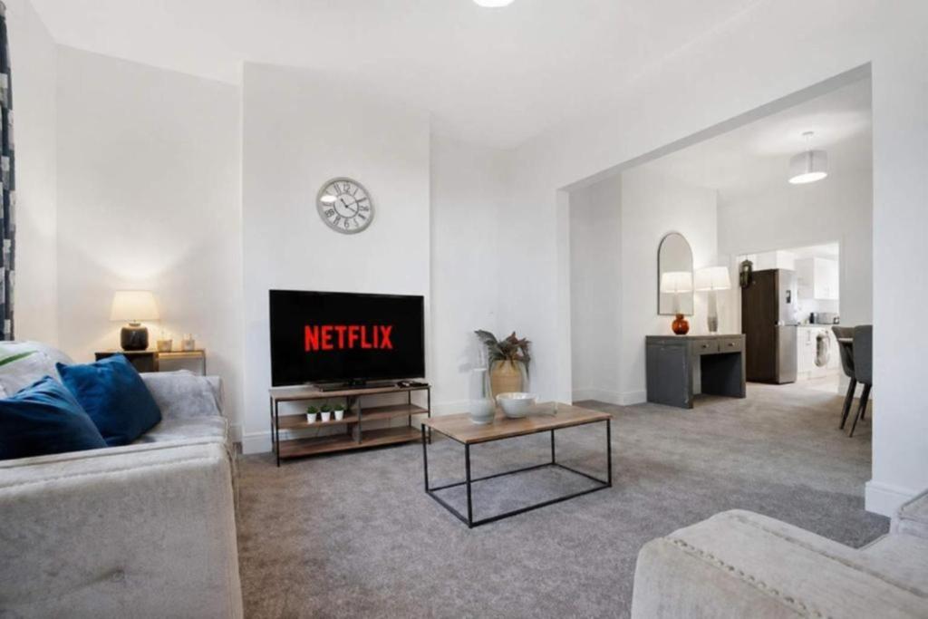 a living room with a couch and a tv at NEW! Spacious 4BR in Sidney in Bishop Auckland