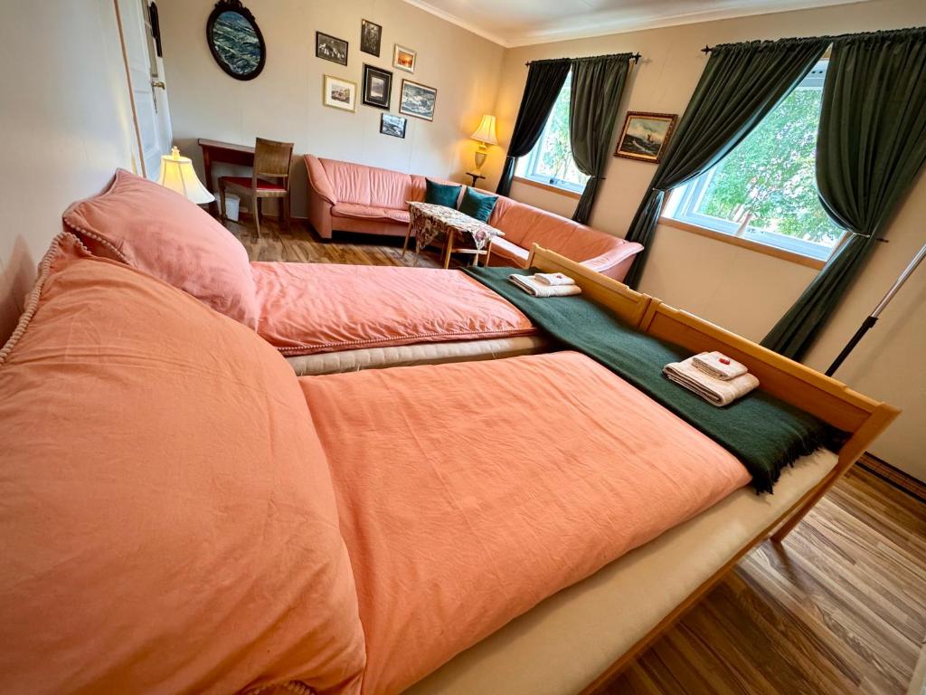 a bedroom with two beds and a living room at Lofoten Light - Private Rooms with Shared Facilities in Gravdal