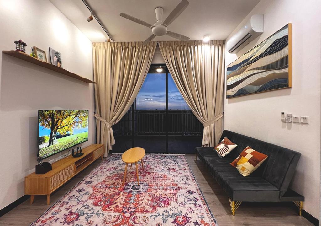 a living room with a black couch and a tv at MySky Putrajaya in Putrajaya