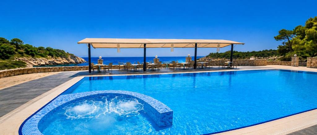 a swimming pool with the ocean in the background at Lalloudes Hotel Mani in Éxo Nímfion