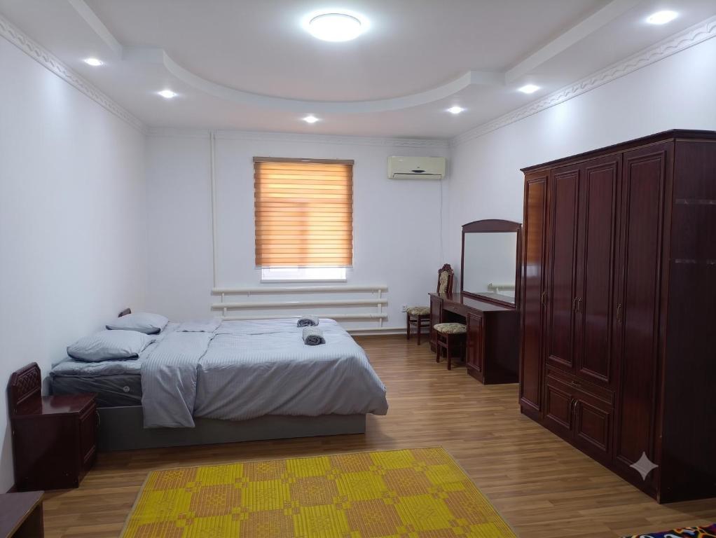 a bedroom with a bed and a dresser and a mirror at Хостел18А in Nukus