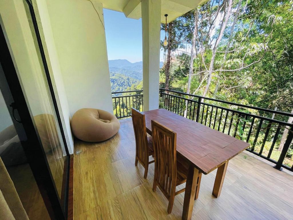 a dining room with a table and chairs on a balcony at Ella Mist Haven in Ella