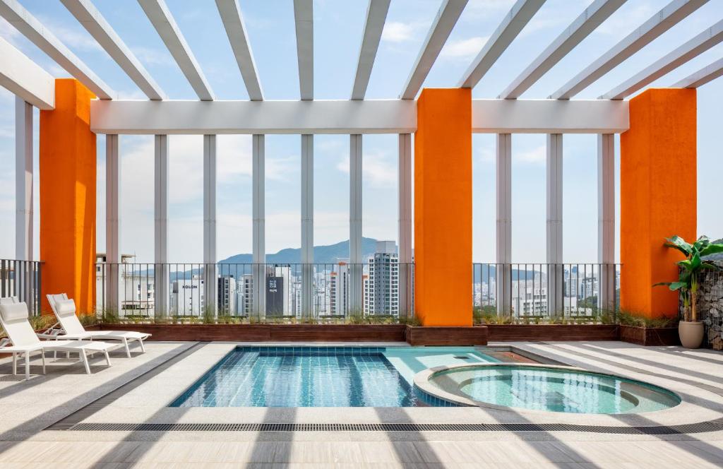 a pool in the middle of a building with large windows at Hyatt Place Busan Yeonsan in Busan