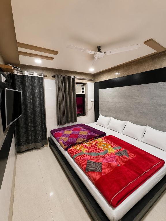 a bedroom with a large bed with a red blanket at Hotel Sundaram 5 Minutes Distance from Dargah in Ajmer