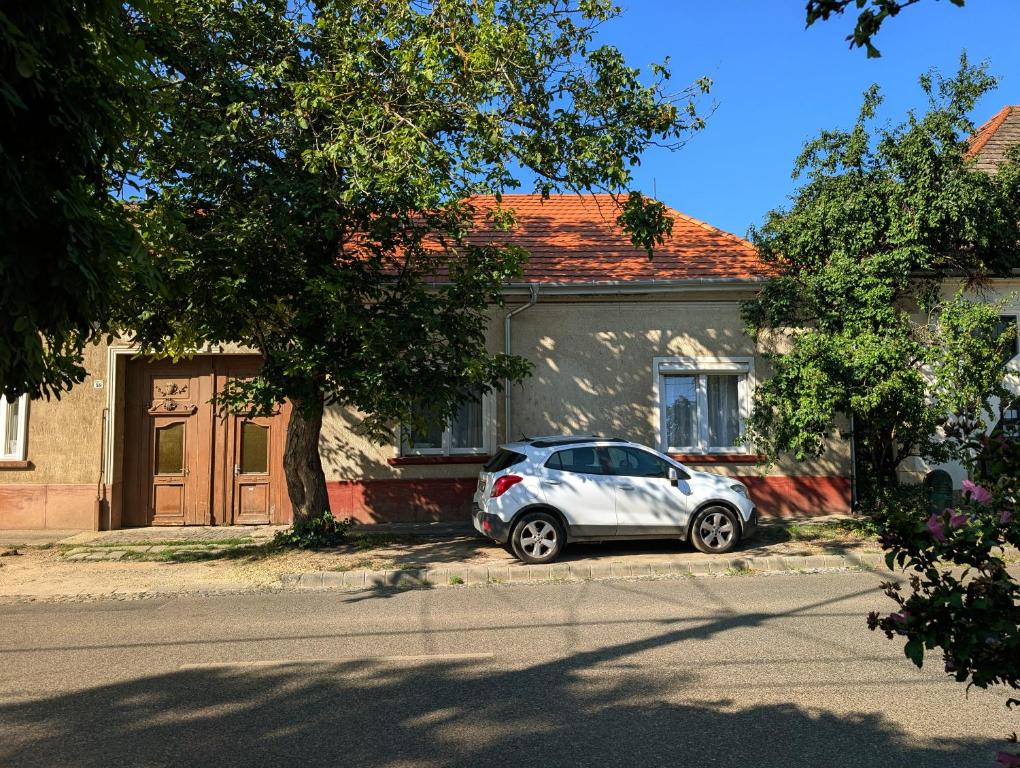a white car parked in front of a house at B57 guesthouse in Budakalász