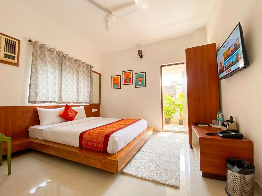 a bedroom with a bed and a television in it at Lake Land Guest House in Kolkata
