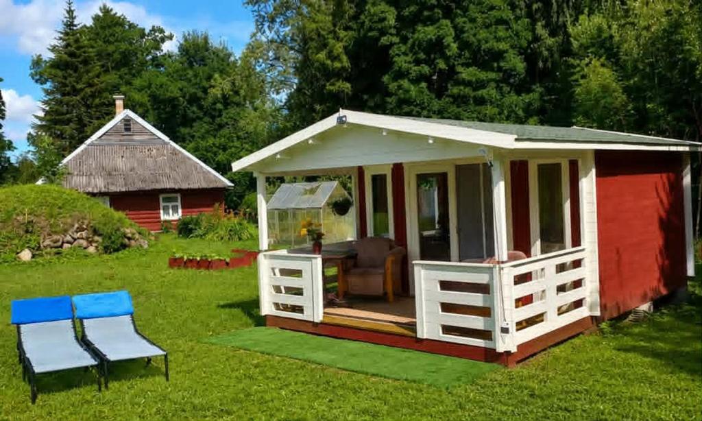 a red and white shed with a table and chairs at Muhu Garden Cabin in Suuremõisa