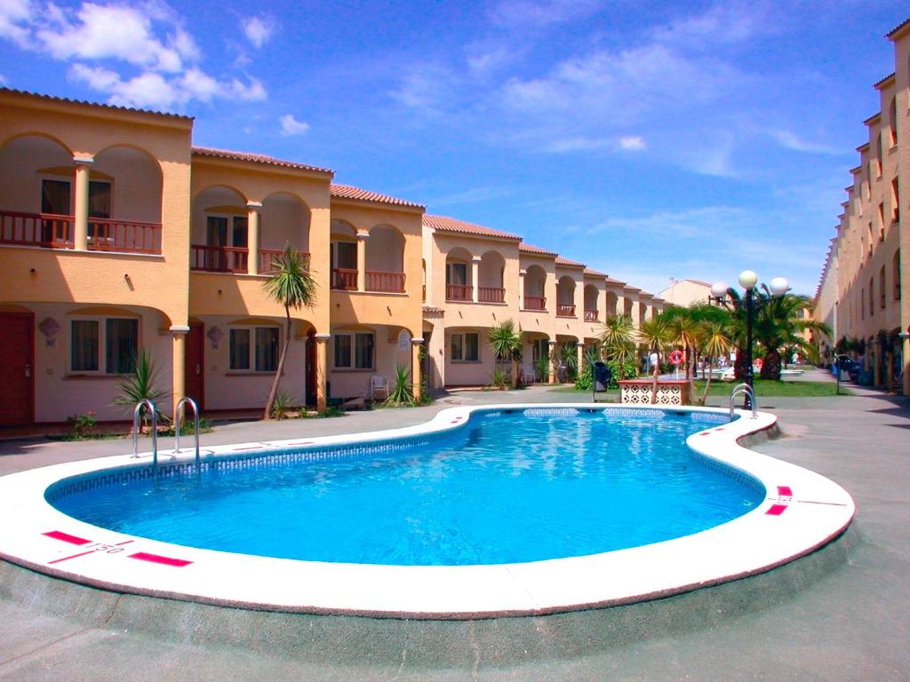 une grande piscine en face de certains bâtiments dans l'établissement Apartamentos turísticos Jardines del Plaza, à Peñíscola