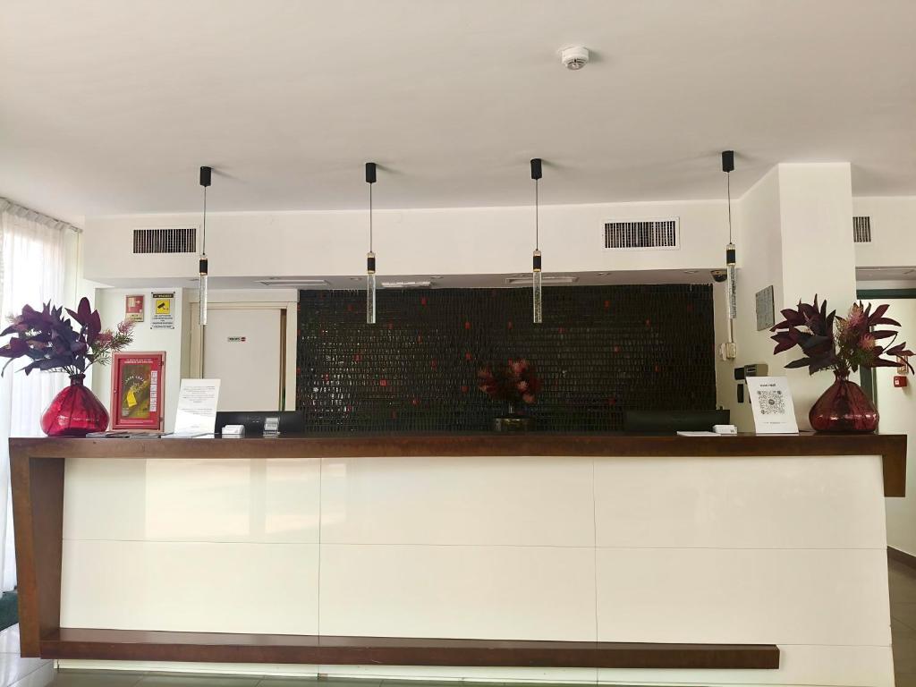 a kitchen with a counter with two red vases at HOTEL HMR RHO Milano in Rho
