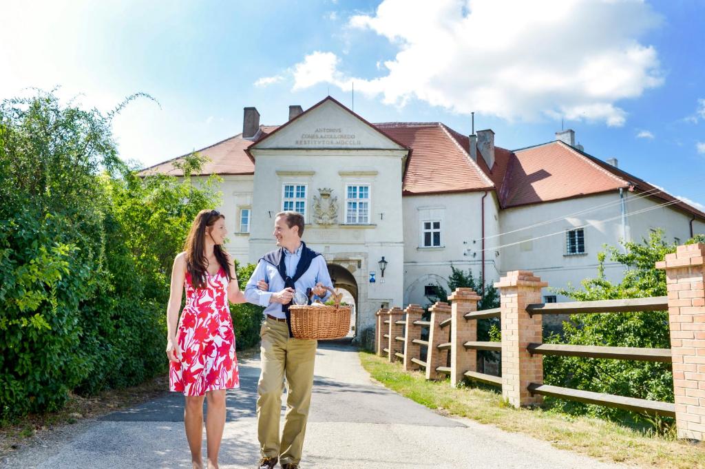 a man and a woman walking in front of a house at Schlosshotel Mailberg in Mailberg