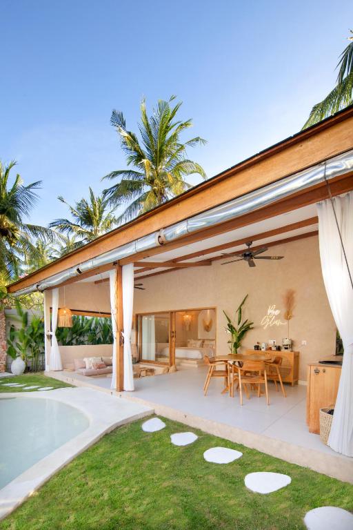 an outdoor patio with a dining area and a house at Gili Boho Villas - Aesthetic Private Pool Villas in Gili Trawangan