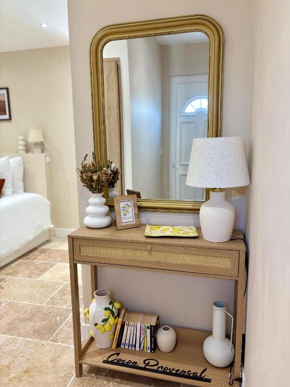 a table with a mirror and a lamp on it at Le Cocon Provençal in Monteux