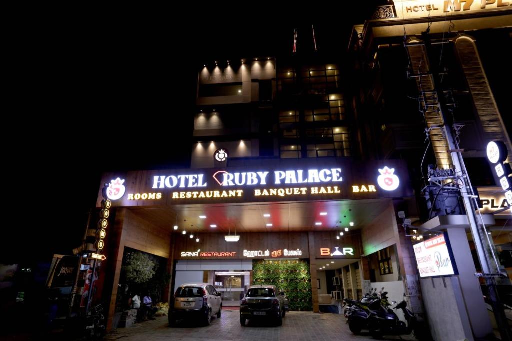 a hotel style palace with cars parked outside at night at HOTEL RUBY PALACE in Tiruchirappalli