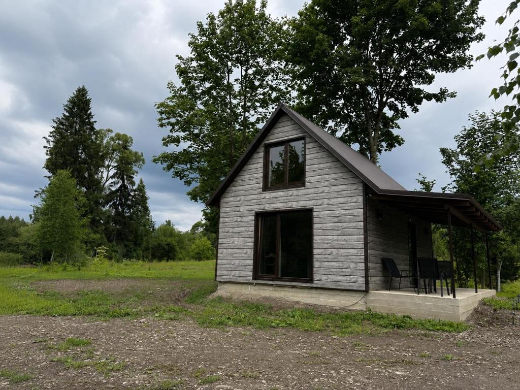 a small house sitting on top of a field at Тиша біля річки in Izki