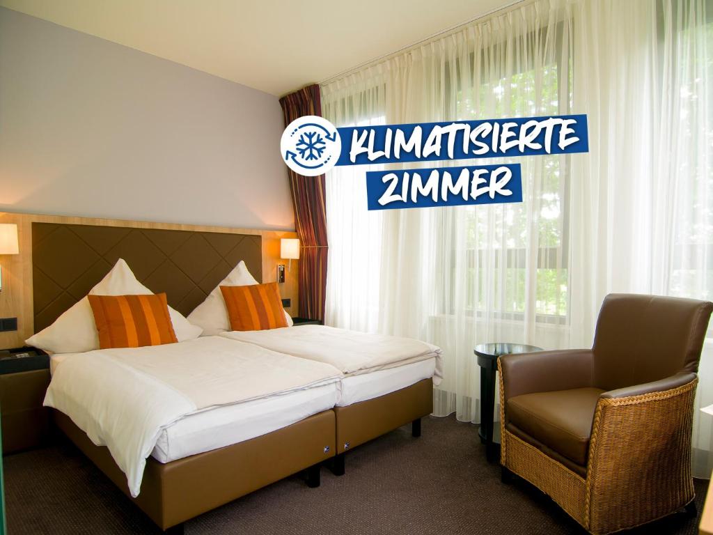 a hotel room with a bed and a chair at ACHAT Hotel München Süd in Munich