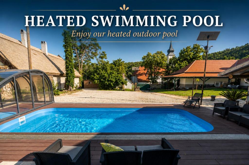 an image of a heated swimming pool in a backyard at Döbrögi Wellness Vendégház in Nemesvita